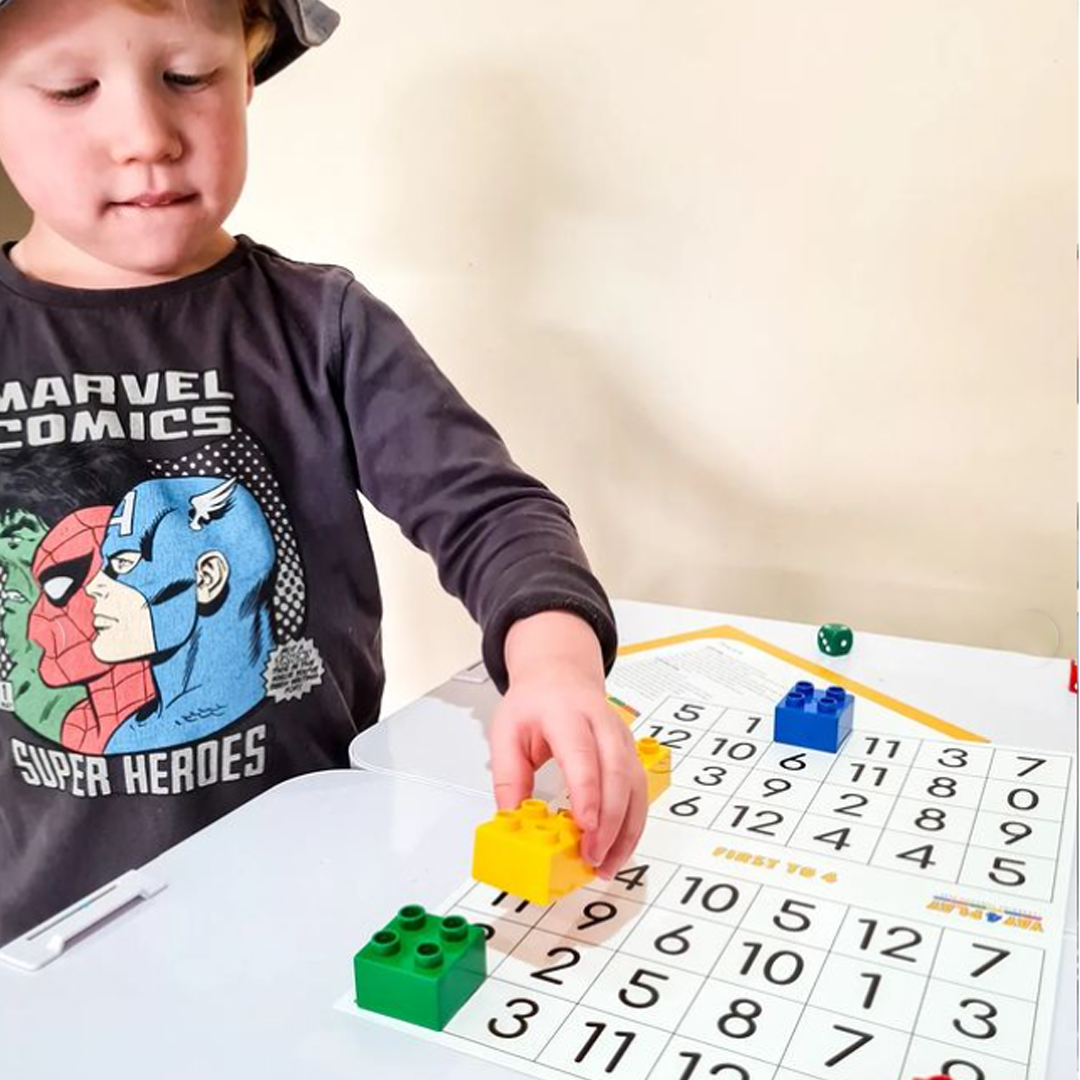 Close-up of a child using fine motor skills to stack bricks.